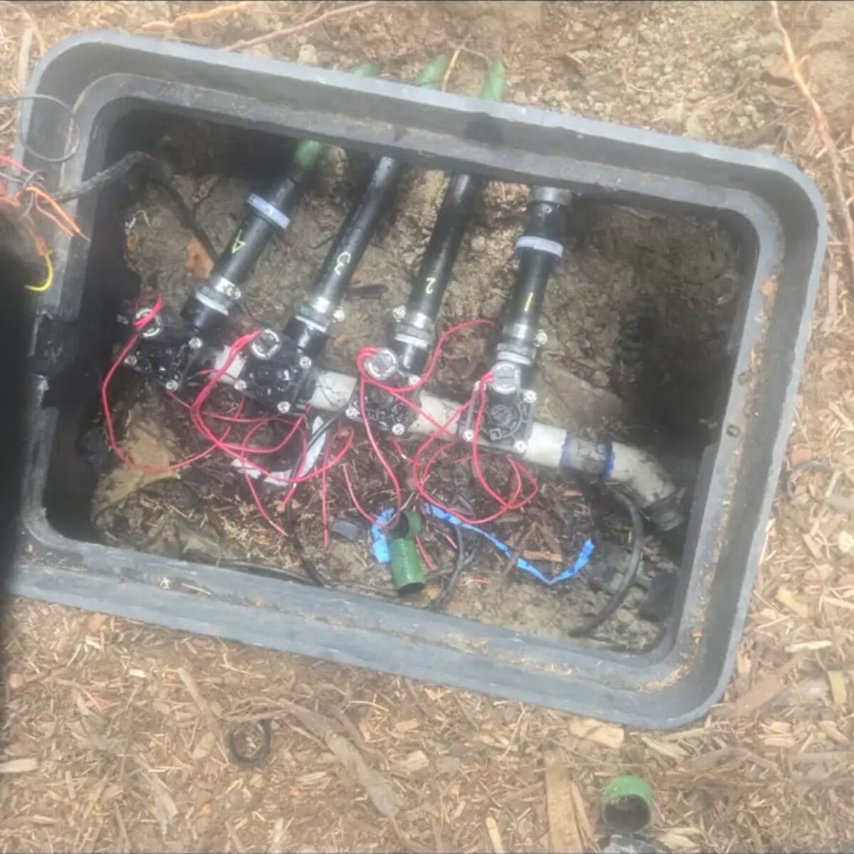 Four zones manifolded and wired in a single box, each line numbered for easy service.